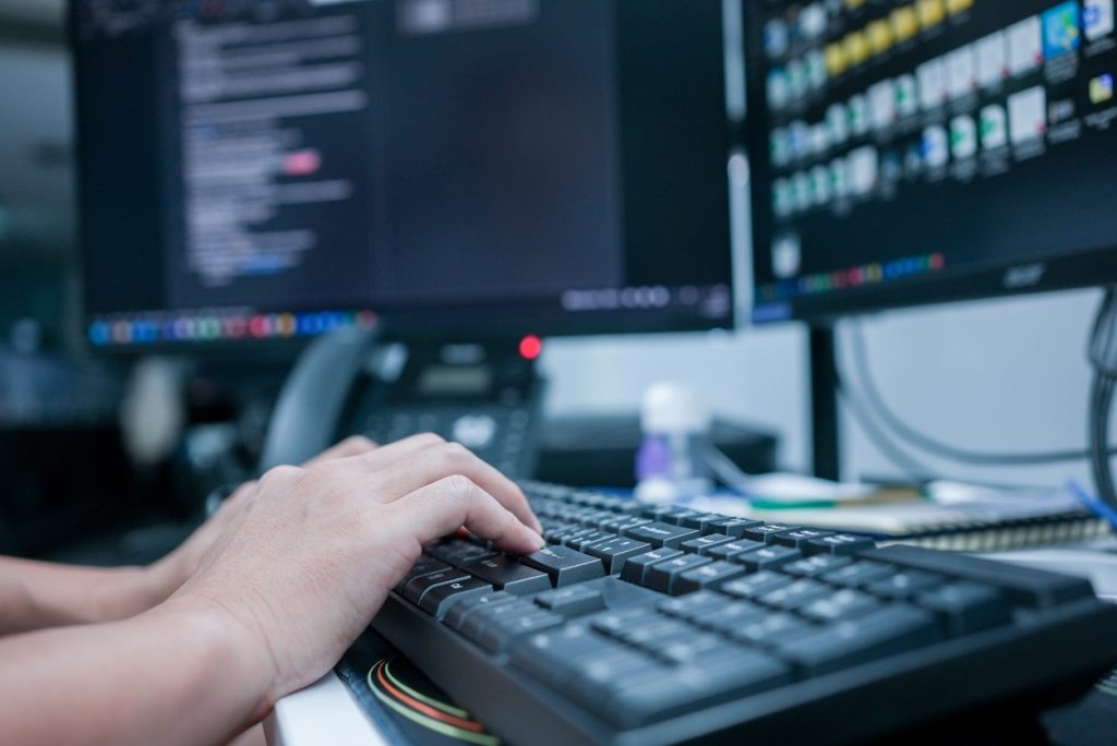 市場調査のためのデータをPCで触る人の手。